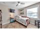 Comfortable bedroom with ceiling fan, wall-mounted TV, and ample natural light at 5101 Coquina Key Se Dr # A, St Petersburg, FL 33705