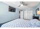 Bright bedroom featuring a tile floor, ceiling fan, mounted TV, white closet doors and a view to the bathroom at 5101 Coquina Key Se Dr # A, St Petersburg, FL 33705