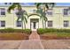 Inviting light green two-story condo building entrance with brick walkway and tropical landscaping at 5101 Coquina Key Se Dr # A, St Petersburg, FL 33705