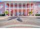 Elegant two-story building featuring columns, walkways, and brick entryway with tropical plants and lush landscaping at 5101 Coquina Key Se Dr # A, St Petersburg, FL 33705