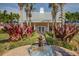 Community clubhouse with a brick entrance, a water fountain, manicured foliage, and palm trees at 5101 Coquina Key Se Dr # A, St Petersburg, FL 33705