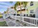 A two-story home is complemented by a patio, white fencing, and a lush palm tree in a tropical setting at 5101 Coquina Key Se Dr # A, St Petersburg, FL 33705