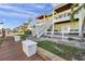 Exterior of waterfront townhomes showing walkway, outdoor stairs, landscaping and architectural details at 5101 Coquina Key Se Dr # A, St Petersburg, FL 33705