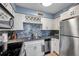 Updated kitchen features white cabinets, stainless steel appliances, mosaic tile backsplash, and wine rack at 5101 Coquina Key Se Dr # A, St Petersburg, FL 33705