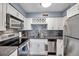 Updated kitchen features white cabinets, stainless steel appliances, mosaic tile backsplash, and wine rack at 5101 Coquina Key Se Dr # A, St Petersburg, FL 33705