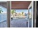 View of waterfront homes from a partially enclosed outdoor patio with brick flooring and black metal furniture at 5101 Coquina Key Se Dr # A, St Petersburg, FL 33705
