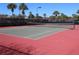Community tennis court featuring a grey surface with red borders and a black net at 5101 Coquina Key Se Dr # A, St Petersburg, FL 33705