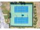 Aerial view of outdoor tennis courts with blue surface surrounded by trees at 5101 Coquina Key Se Dr # A, St Petersburg, FL 33705