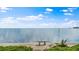 Scenic water view shows a bench and plant life next to bay, with the sky dotted with clouds above at 5101 Coquina Key Se Dr # A, St Petersburg, FL 33705