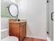 Charming bathroom with a wooden vanity and unique round mirror at 545 Pinellas Bayway S # 108, St Petersburg, FL 33715