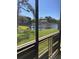 Screened balcony showing a pond view with green grass and community buildings at 6070 80Th N St # 109, St Petersburg, FL 33709