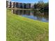 Lush green lawn leading to a tranquil pond reflects nearby building exteriors at 6070 80Th N St # 109, St Petersburg, FL 33709