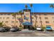 Spacious multi-level condo building with palm trees, covered entrance and ample parking spaces for residents and visitors at 6100 Gulfport S Blvd # 414, Gulfport, FL 33707