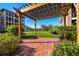 Exterior view of common area pergola, a brick-paved patio, and lush greenery at 6100 Gulfport S Blvd # 414, Gulfport, FL 33707