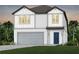 Charming two-story home with white siding, gray trim, a two-car garage, and well-manicured landscaping at 6217 Golden Beach Dr, Apollo Beach, FL 33572