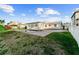 The backyard features a sparkling pool, lush green lawn, and a charming white fence at 720 Capri Blvd, Treasure Island, FL 33706