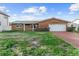 Front exterior of brick home with brick driveway and two car garage at 720 Capri Blvd, Treasure Island, FL 33706
