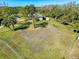 An aerial view of a home showing the grassy lawn and mature trees at 8437 Indies Dr, Hudson, FL 34667