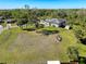 Aerial view of the large grassy yard with mature trees and the back of the house at 8437 Indies Dr, Hudson, FL 34667