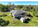 Aerial view of the backyard with a deck, fire pit, shed and screen porch at 8437 Indies Dr, Hudson, FL 34667