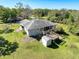 The backyard features a wooden deck and shed, set against a backdrop of lush greenery at 8437 Indies Dr, Hudson, FL 34667