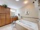 Bathroom featuring a standalone tub, wooden cabinets, and granite countertops at 8437 Indies Dr, Hudson, FL 34667
