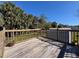 View of the wooden backyard deck with wooden railings and a shed at 8437 Indies Dr, Hudson, FL 34667