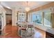 Cozy dining room area with bright light from a window and a decorative chandelier at 8437 Indies Dr, Hudson, FL 34667