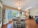Light-filled dining room features wood floors, decorative chandelier, and large window with garden view at 8437 Indies Dr, Hudson, FL 34667