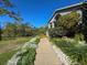 Exterior view of a gray home showcasing meticulously landscaped walkway and a cozy front yard at 8437 Indies Dr, Hudson, FL 34667