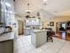 This kitchen features an island bar and an open layout to a room with hardwood flooring at 8437 Indies Dr, Hudson, FL 34667