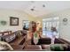 Spacious living room with wood floors, large leather sofa, and view of the sunroom at 8437 Indies Dr, Hudson, FL 34667