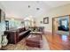 Bright and airy living room showcasing wood floors, leather sofa, and easy access to dining area at 8437 Indies Dr, Hudson, FL 34667