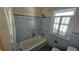 Bathroom with tiled walls, a white tub with shower curtain, and window at 860 16Th S Ave, St Petersburg, FL 33701