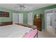 Bright bedroom featuring green walls, carpet floors, ceiling fan and a dresser with a TV at 8746 Tantallon Cir, Tampa, FL 33647