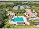 Aerial view showcasing a large community pool, slide, cabana, tennis courts, and meticulously maintained landscaping at 8746 Tantallon Cir, Tampa, FL 33647