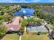 Overhead shot of the community pool, clubhouse, and tennis court next to a lake with a fountain at 8746 Tantallon Cir, Tampa, FL 33647