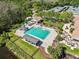 Aerial view featuring a community pool, slide, cabana, and lush greenery with tennis courts and a clubhouse nearby at 8746 Tantallon Cir, Tampa, FL 33647