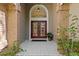 Inviting entryway with brick pillars, double doors, transom window, neutral tile and vibrant greenery at 8746 Tantallon Cir, Tampa, FL 33647