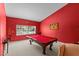 Game room with red walls, carpet floors, and a pool table next to a window at 8746 Tantallon Cir, Tampa, FL 33647