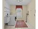 Laundry room with a washing machine, dryer and a metal rack at 8746 Tantallon Cir, Tampa, FL 33647