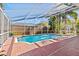 Enclosed pool with a red brick deck and a view of the yard at 8746 Tantallon Cir, Tampa, FL 33647