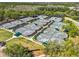Aerial view of multiple tennis courts with green surfaces and dark green canopies, surrounded by lush trees and landscaping at 8746 Tantallon Cir, Tampa, FL 33647