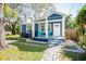Charming blue bungalow with a cozy front porch and vibrant turquoise chairs at 8909 N Dexter Ave, Tampa, FL 33604