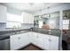 Well-lit kitchen with granite countertops, stainless steel dishwasher and sink, and plenty of cabinet space at 8909 N Dexter Ave, Tampa, FL 33604