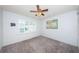 Bright bedroom with neutral carpet, ceiling fan, and ample natural light from the large window at 9214 Mission Oaks Blvd, Seminole, FL 33776