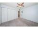 The bedroom has a ceiling fan, large closet space, neutral carpet, and light blue walls at 9214 Mission Oaks Blvd, Seminole, FL 33776