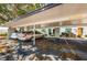 This is a carport with two parking spaces under building 26 with landscaping visible in the background at 9214 Mission Oaks Blvd, Seminole, FL 33776