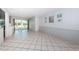 The expansive living room has tile flooring and is brightly lit from the natural light entering through sliding glass doors at 9214 Mission Oaks Blvd, Seminole, FL 33776