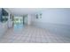 Bright living room featuring white tile flooring and sliding glass doors at 9214 Mission Oaks Blvd, Seminole, FL 33776